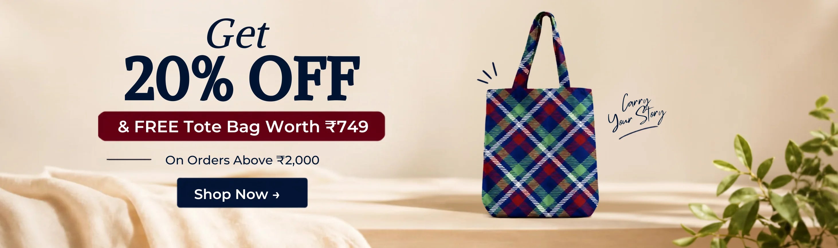 Promotional banner for a free tote bag, featuring a navy blue plaid tote bag on a beige platform with text offering 20% off and a free tote bag worth ₹749.