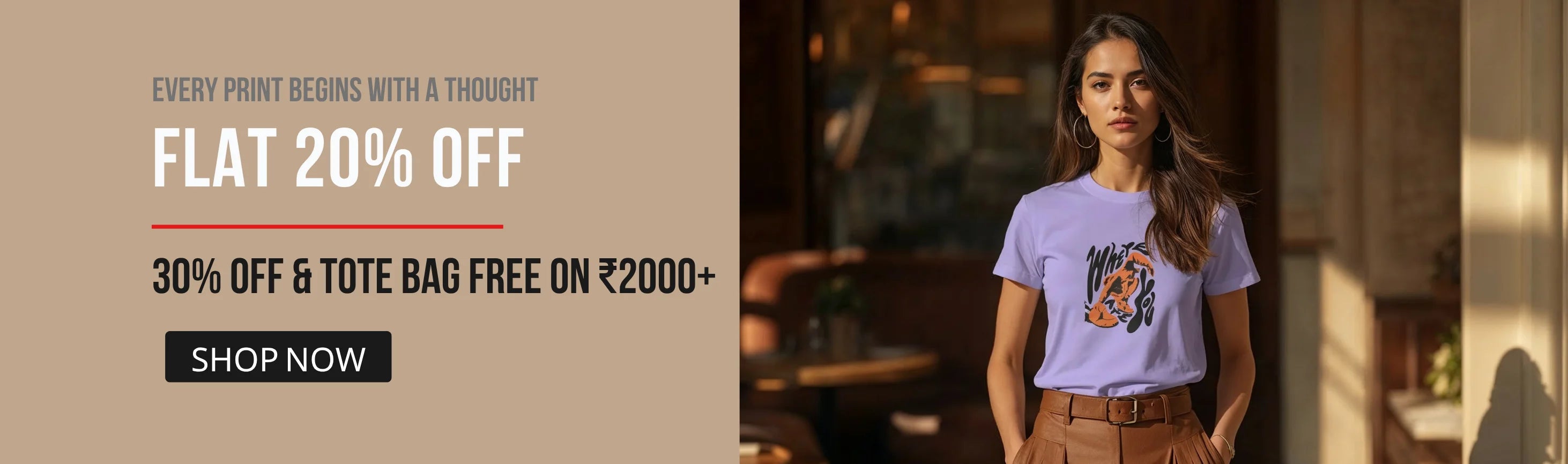 A promotional banner featuring a woman wearing a light purple graphic t-shirt and brown pants, standing in a warmly lit indoor setting. The left side has a beige panel with text reading 'EVERY PRINT BEGINS WITH A THOUGHT', 'FLAT 20% OFF', '30% OFF & TOTE BAG FREE ON ₹2000+', and a 'SHOP NOW' button.